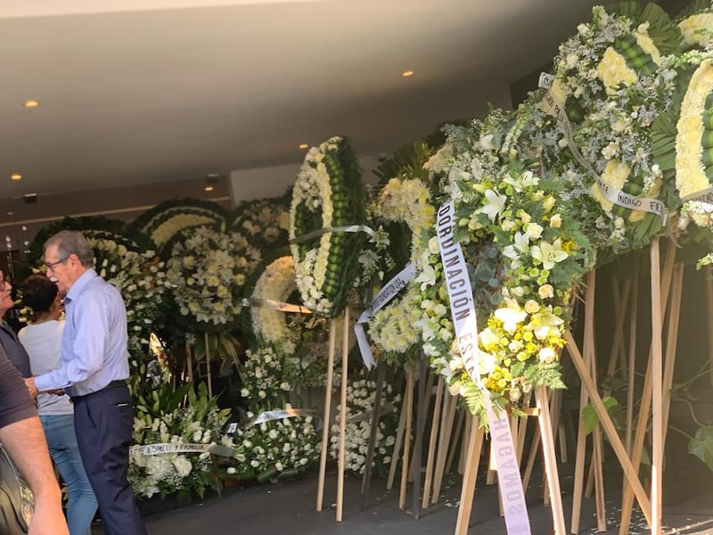 En la funerario han dejado cientos de coronas fúnebres para el exrector.