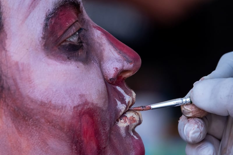 Asistentes comienzan a maquillarse previo a la salida de la edición 2022 de la Marcha Zombie del Monumento a la Revolución al Zócalo capitalino.