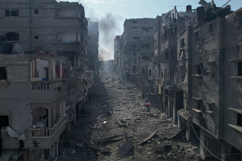 Escombros cubren una calle entre edificios en llamas afectados por un ataque aéreo israelí en Jabaliya, Franja de Gaza, el miércoles 11 de octubre de 2023. (Foto AP/Hatem Moussa)