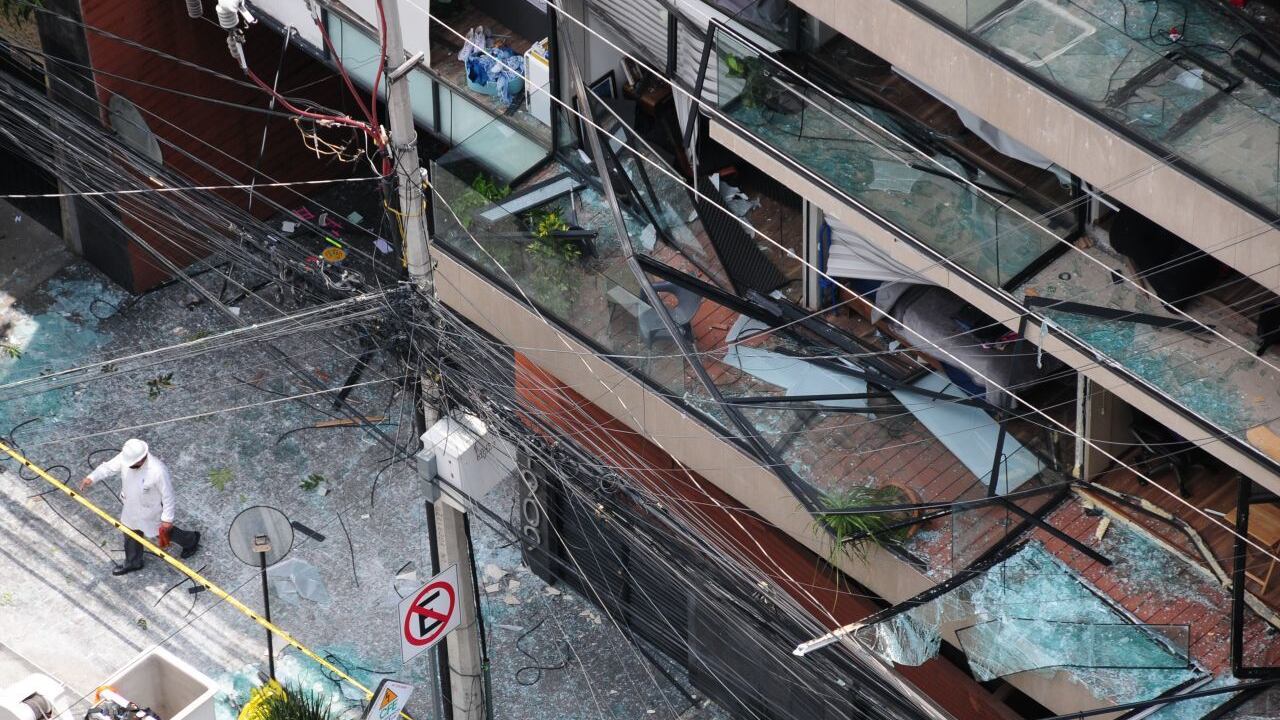 Un perito de la FGJ de la ciudad sale del edificio dañado por la explosión.
