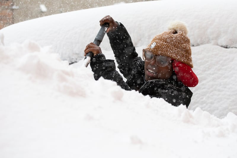 Zaria Black, de Buffalo, quita la nieve de su auto en Buffalo, Nueva York, EEUU, viernes 18 de noviembre de 2022.