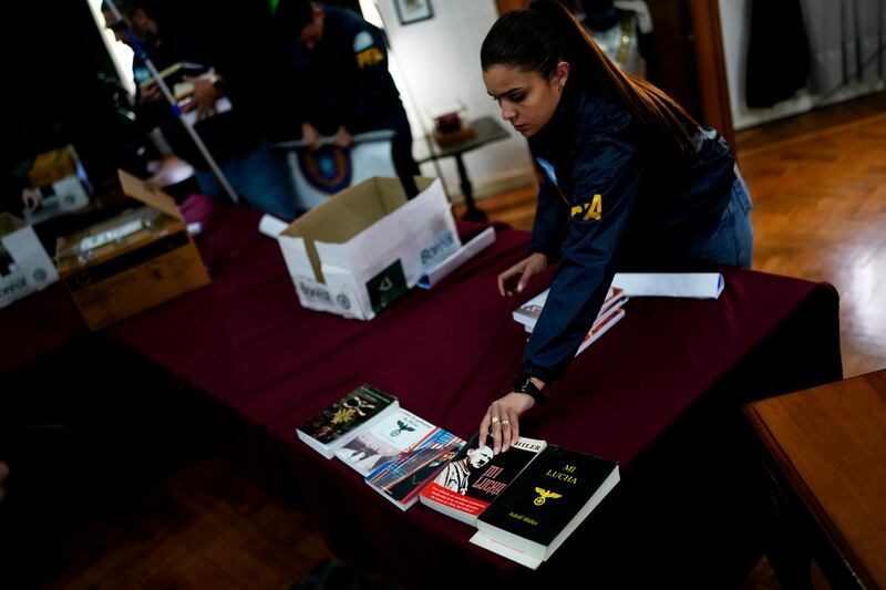 Agentes federales colocaron libros incautados dentro de cajas después de exhibirlos a la prensa en la sede de la Policía Federal en Buenos Aires, Argentina, el miércoles 13 de septiembre de 2023.  (AP Foto/Natacha Pisarenko)