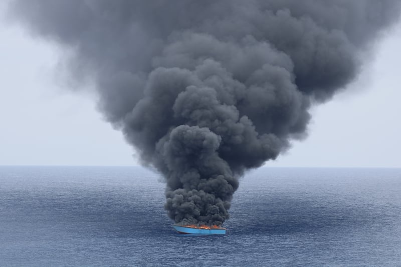 Mar Mediterráneo Central, junio de 2023. Humo negro sale de un barco de madera tras ser interceptado por la Guardia Costera de Libia. El barco llevaba alrededor de 50 personas a bordo, que fueron trasladadas al barco de la Guardia Costera antes de que le prendieran fuego al barco de madera.