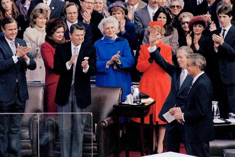 El presidente electo Ronald Reagan aplaude mientras el presidente saliente Jimmy Carter saluda a la multitud en la ceremonia inaugural de Reagan, en Washington, el 20 de enero de 1981. (Foto AP, archivo)