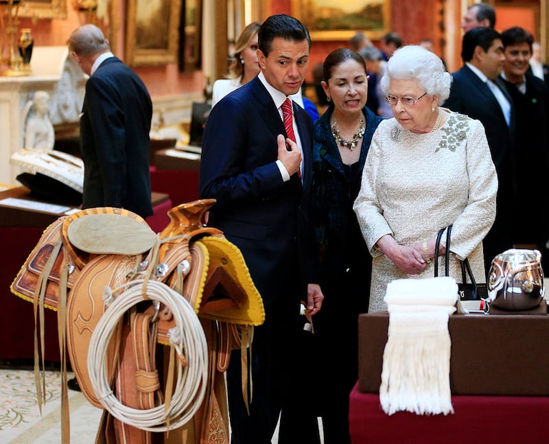 LONDRES, INGLATERRA - 03 DE MARZO: El Presidente de México, Enrique Peña Nieto (centro), es mostrado por la Reina Isabel II en el Palacio de Buckingham, artículos mexicanos de la Colección Real, el 3 de marzo de 2015, en Londres, Inglaterra. El Presidente de México, acompañado por la Señora Angélica Rivera de Peña, se encuentran de visita de Estado en el Reino Unido como invitados de Su Majestad La Reina desde el martes 3 de marzo hasta el jueves 5 de marzo.  (Foto de Jonathan Brady - WPA Pool /Getty Images)