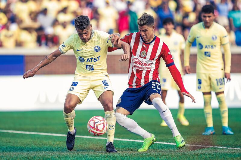 Jonathan Dos Santos disputa un balón con Cristian Calderón de Chivas