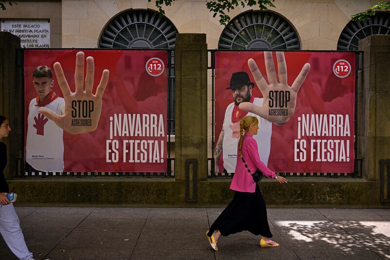 Gente camina frente a publicidad que hace un llamado a detener las agresiones sexuales (AP).