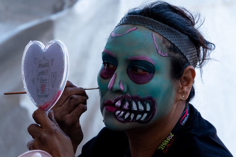 Asistentes comienzan a maquillarse previo a la salida de la edición 2022 de la Marcha Zombie del Monumento a la Revolución al Zócalo capitalino.