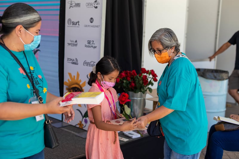 A los participantes les regalan un ejemplar de la obra y una rosa.