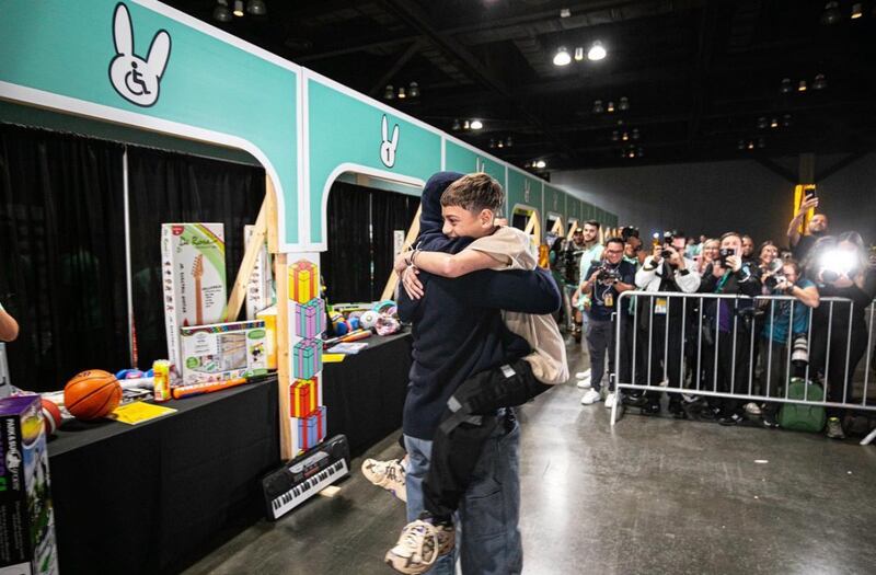 Bad Bunny abrazando a niño durante entrega de regalos 2023.