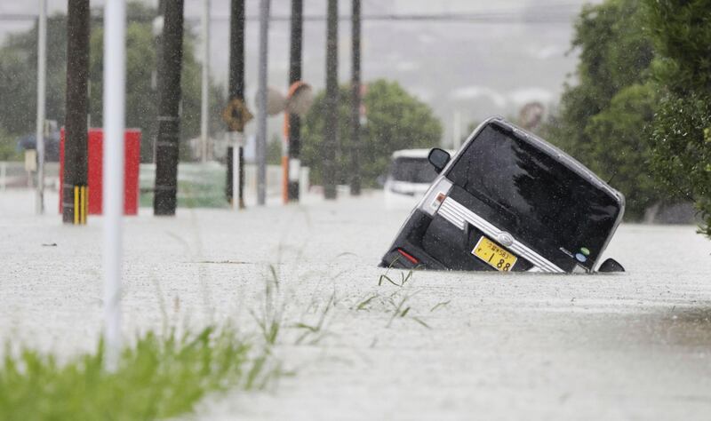 En vehículo está atascado sobre una calle inundada debido a una lluvia en Kurume, al sur de la prefectura de Fukuoka, en Japón (AP).