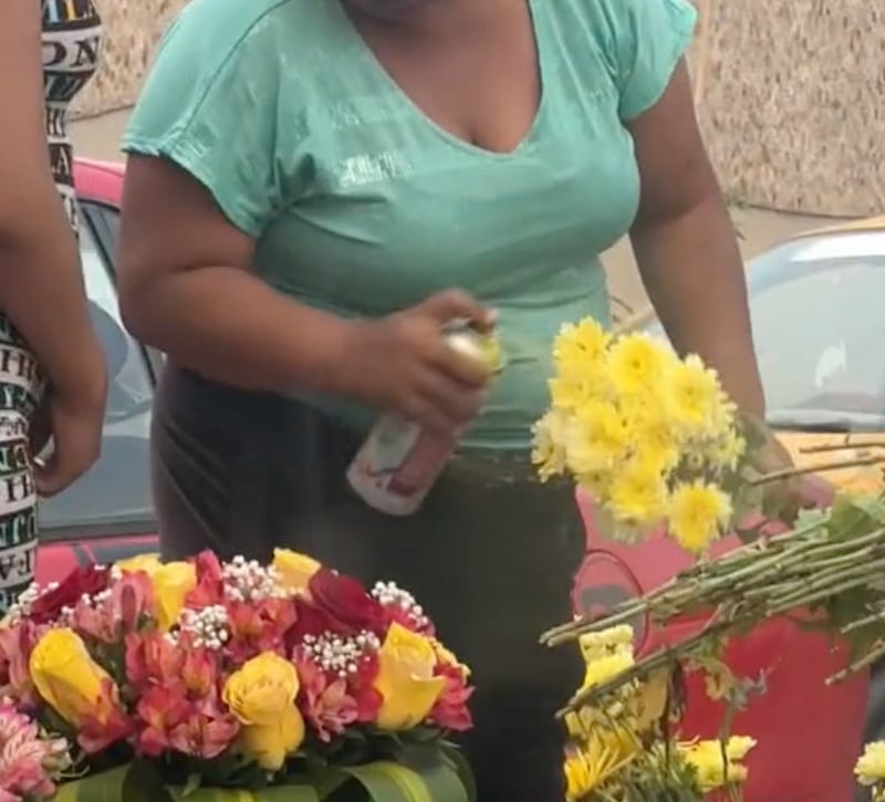 Mujer pinta un ramo de flores con un aerosol