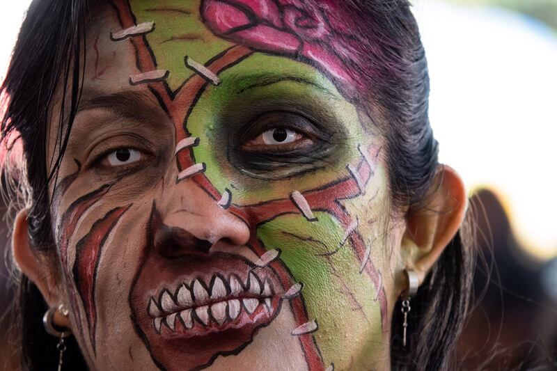 Asistentes comienzan a maquillarse previo a la salida de la edición 2022 de la Marcha Zombie del Monumento a la Revolución al Zócalo capitalino.