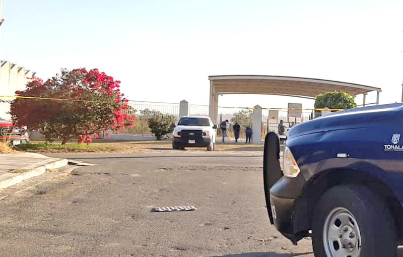 El cuerpo del agente quedó tirado en el estacionamiento en frente de la escuela.