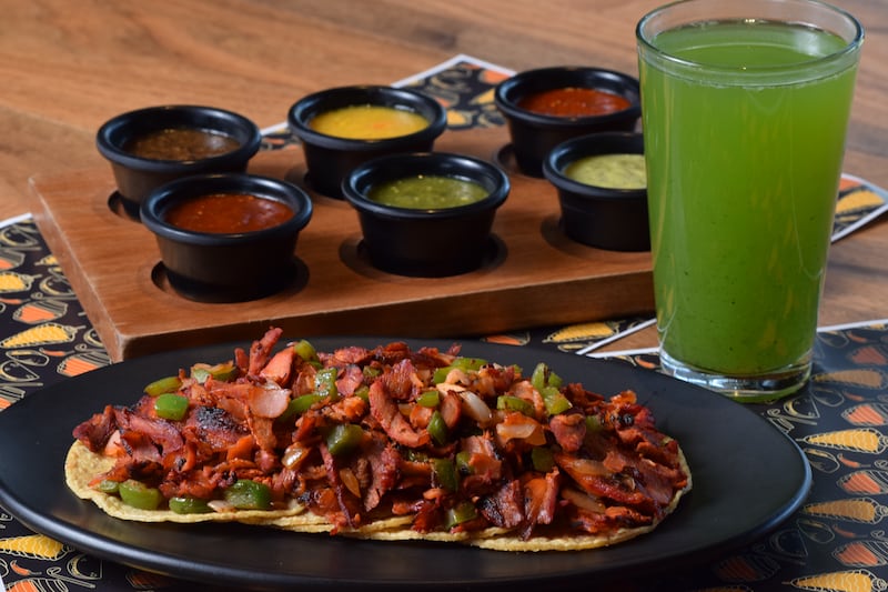 Plato con alambre de pastor, un vaso de agua fresca y juego de salsas.